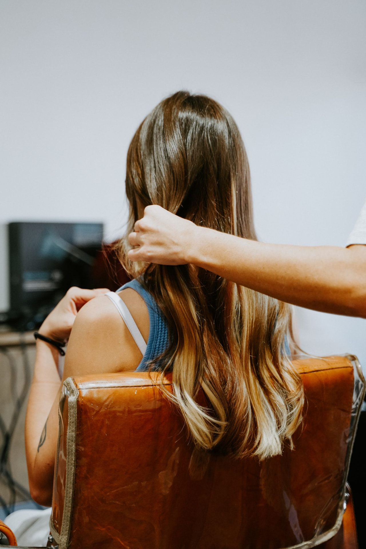 Long blonde hair extensions being checked by a Blur. Salon stylist in Oklahoma City